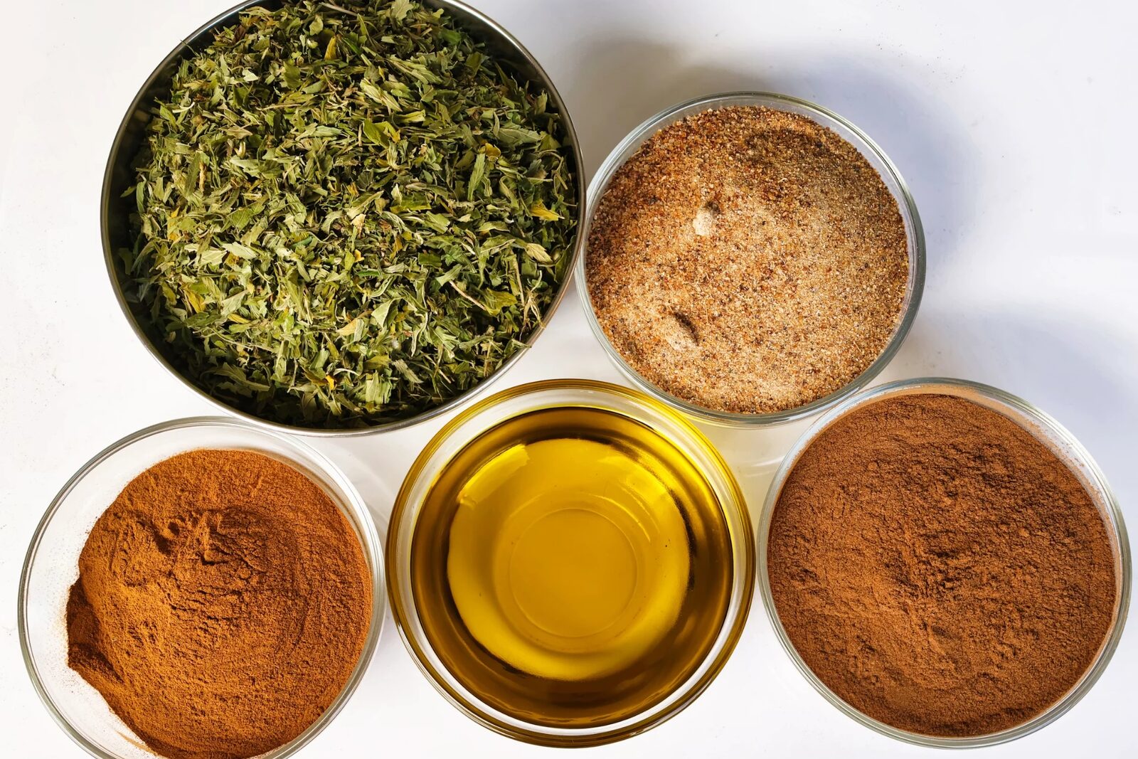 Botanical powders, granulates and an oil sample presented in laboratory dishes