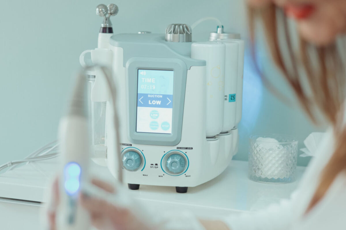 Practitioner using a professional facial treatment device in a wellness centre